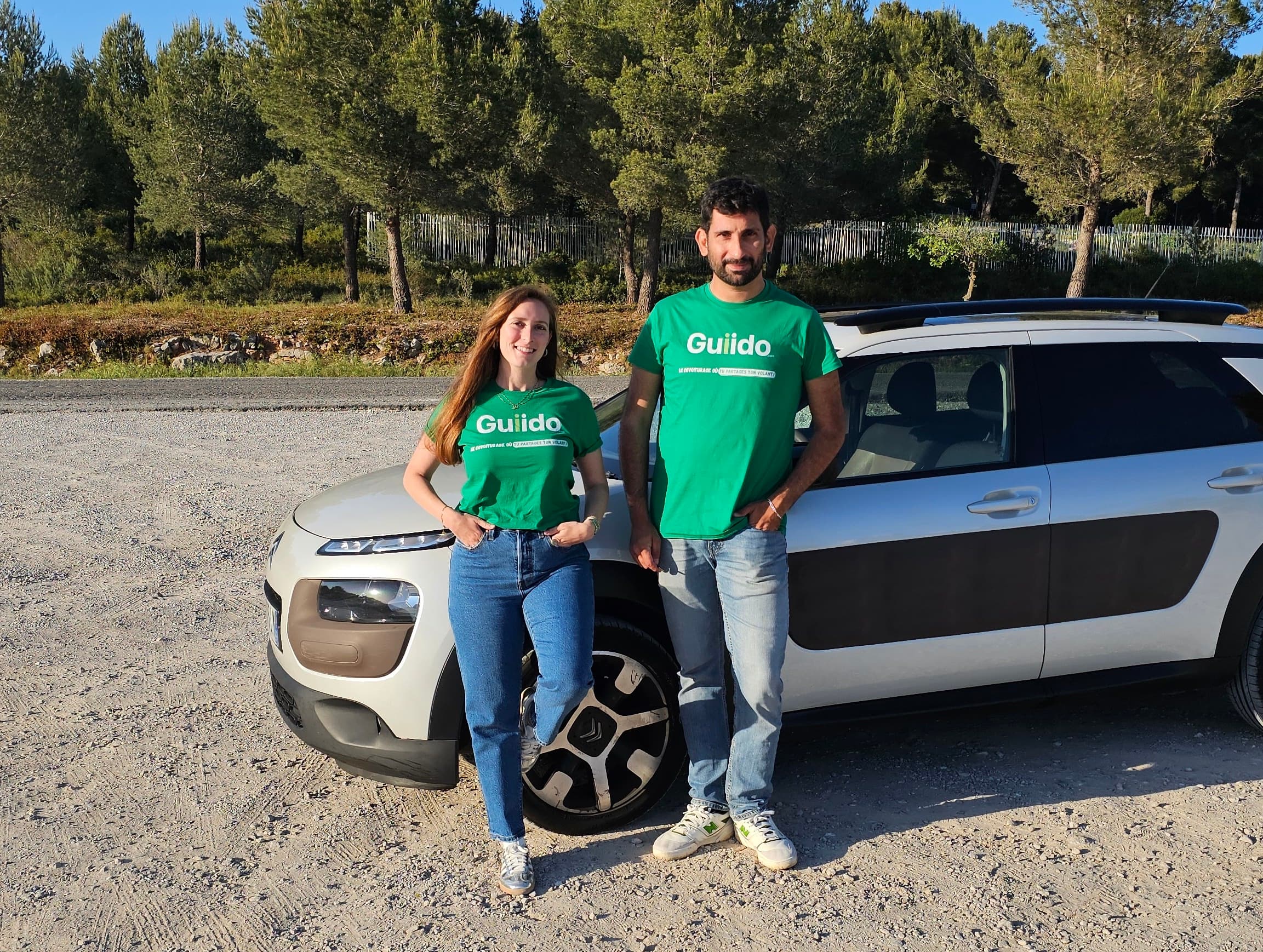 Alice et Enrico, cofondateurs de Guiido, devant leur voiture